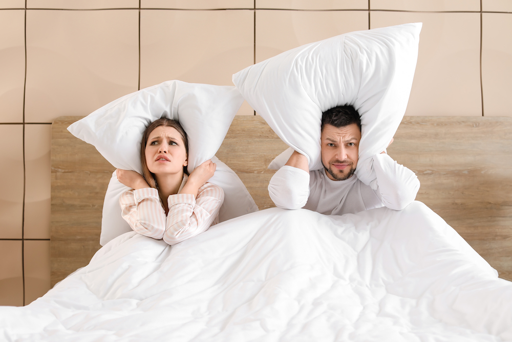 A young couple cannot sleep because of rowdy neighbors